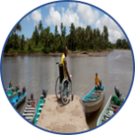 A wheelchair user waits on ta dock with boats but none accessible