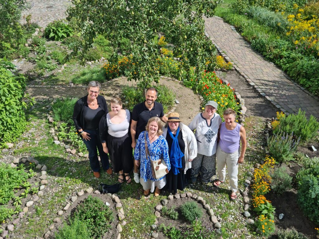 Aerial photograph of a group of people standing together outside and looking up at the camera. 