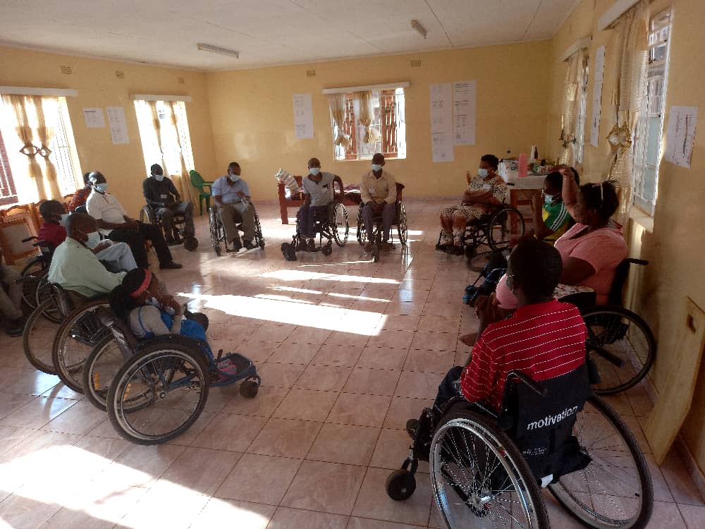 A group of people in wheelchairs engaged in a conversation. 