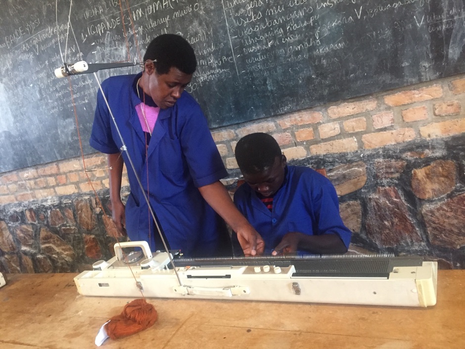 A teacher shows a student with a visual impairment how to use a machine