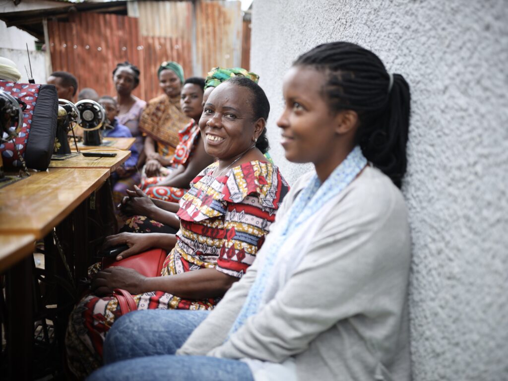 A group of women sitting around a sewing machine in Kigali