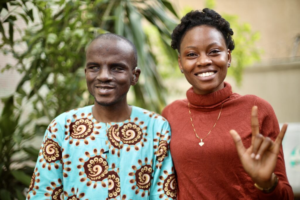 Soloman and Alataise smile at the camera. Alataise signs "I love you."