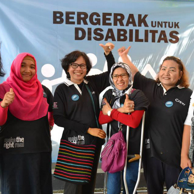 Four Indonesia women smiling and giving thumbs up signs.